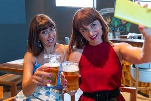 Due femmina amici prendere un' autoscatto mentre potabile birra foto