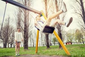 giovane donna spinge sua fidanzato su il swing foto