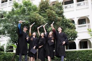 gruppo di studenti di successo che lanciano cappelli da laurea in aria e festeggiano