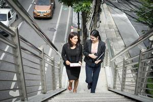 giovani donne d'affari asiatiche con documenti che camminano sulle scale foto