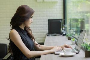 giovane donna d'affari che lavora al computer portatile in ufficio foto