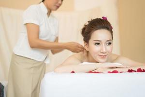 giovane bella donna con un sano massaggio in un salone spa foto