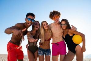 gruppo di amici giocando a spiaggia volley a il spiaggia foto