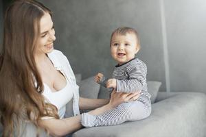 poco bambino sorridente e contento con mamma foto