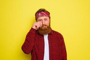 triste uomo con barba e bandana nel testa grida foto