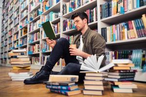 ragazzo legge un' libro nel un' biblioteca. concetto di curiosità, immaginazione e cultura foto