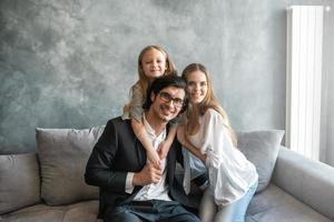 contento poco ragazza giocare con sua madre e padre foto