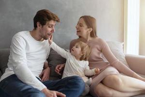 contento poco ragazza giocare con sua madre e padre foto