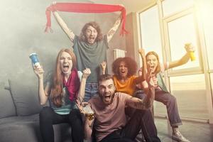 contento amici di calcio fan Guardando calcio su tv e festeggiare vittoria foto