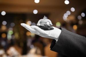 Cameriere con campana nel mano. concetto di primo classe servizio nel il tuo ristorante. foto
