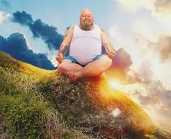 divertente uomo con barba nel yoga posizione all'aperto nel un' montagna foto