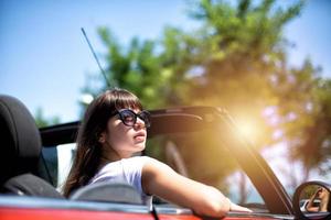 giovane donna nel cabriolet auto parte per il estate vacanze foto