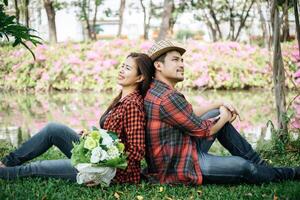 romantico giovane coppia seduta nel giardino foto