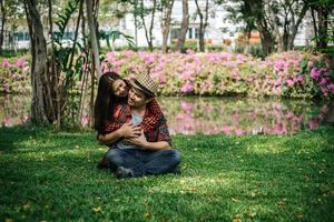romantico giovane coppia seduta nel giardino foto