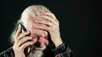 vecchio uomo prende un' cattivo notizia su il Telefono foto