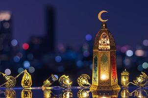 lanterna quello avere Luna simbolo su superiore e decorato leggero con notte cielo e città bokeh leggero sfondo per il musulmano festa di il santo mese di Ramadan kareem. foto