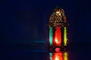 lanterna mette su tavolo con buio blu sfondo per il musulmano festa di il santo mese di Ramadan kareem. foto