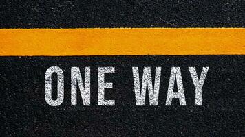 uno modo testo scritto e giallo linea su il strada nel mezzo di il asfalto strada, uno modo parola su strada. foto