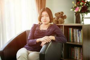 giovane asiatico donna corto capelli rilassamento nel vivente camera foto
