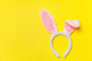 contento Pasqua concetto. decorativo coniglietto orecchie peloso costume giocattolo isolato su di moda giallo sfondo foto