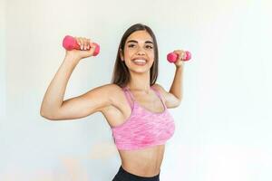 atletico donna fare esercizio per braccia. fitness modello Lavorando su con manubri. donna esercizio con manubri. fitness, allenamento, salutare vivente e dieta concetto. donna fare ginnastica esercizi. foto