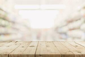 vuoto di legno tavolo e sfocato sfondo - memorizzare di shopping centro commerciale sfocatura sfondo bokeh con Schermo montaggio per Prodotto. foto