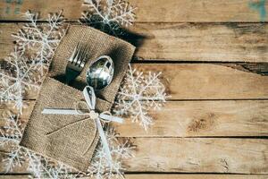 Natale tavolo posto ambientazione e argenteria, i fiocchi di neve su di legno sfondo con spazio. foto