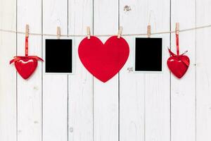 Due foto telaio vuoto e rosso cuore sospeso su bianca legna sfondo con spazio