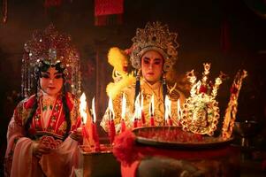 maschio e femmina Cinese musica lirica attori leggero un' candela per pregare omaggio per il di Dio per migliorare il prosperità per te stesso su il occasione foto