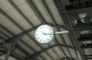 pubblico orologio nel cielo treno stazione con cctv. foto
