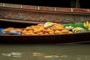 Barche vendita frutta - maturo Mango - nel damnoen saduak galleggiante mercato è un' popolare turista destinazione quello europei e Cinese piace per viaggio con il tradizionale modo di vita di il abitanti del villaggio. foto