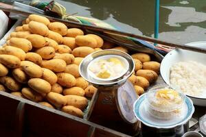 Barche vendita frutta - maturo Mango - nel damnoen saduak galleggiante mercato è un' popolare turista destinazione quello europei e Cinese piace per viaggio con il tradizionale modo di vita di il abitanti del villaggio. foto