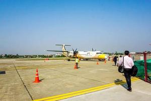 lampang, Tailandia 2018 lungo tiro di il turista e uomini d'affari camminare su il aereo di nok aria a il lampang aeroporto per bangkok. foto