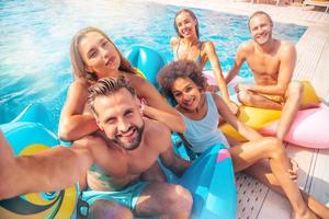 amici nel costume da bagno prendere un' autoscatto nel il nuoto piscina foto