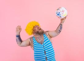 Grasso uomo con barba e parrucca giocare con il palla foto