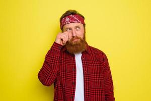 triste uomo con barba e bandana nel testa grida foto