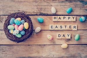 colorato Pasqua uovo nel il nido e di legno testo di contento Pasqua giorno su legna sfondo con spazio foto