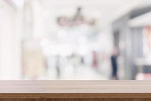 vuoto di legno tavolo superiore con sfocato moderno shopping centro commerciale sfondo per Prodotto Schermo e montaggio. foto