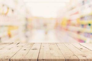 vuoto di legno tavolo e sfocato sfondo - memorizzare di shopping centro commerciale sfocatura sfondo bokeh con Schermo montaggio per Prodotto. foto