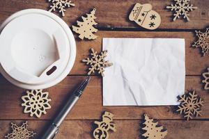 superiore Visualizza tazza caffè e penna, vuoto carta su legna con Natale decorazione per nuovo anno concetto. foto