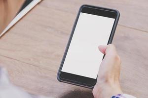 Asia donna mano Tenere e utilizzando Telefono nel caffè negozio. foto