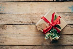 Marrone regalo scatola e fiore su legna tavolo regalo, La madre di giorno concetto. foto
