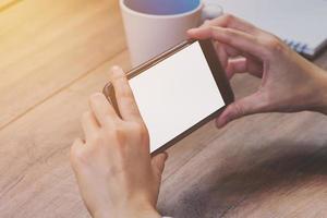 Asia donna mano Tenere e utilizzando Telefono nel caffè negozio. foto