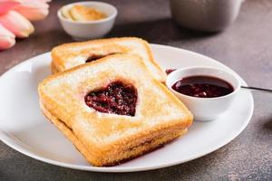 cuore sagomato crostini con lampone marmellata su un' piatto. cibo per amanti. foto