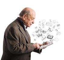 anziano legge libri con tavoletta foto