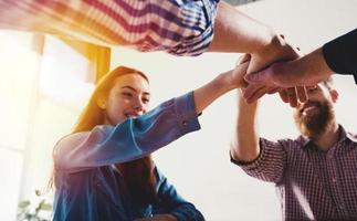 attività commerciale persone mettendo loro mani insieme. concetto di lavoro di squadra e associazione foto