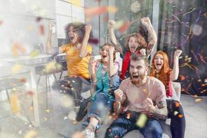 contento amici di calcio fan Guardando calcio su tv e festeggiare vittoria con caduta coriandoli foto