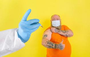 uomo con barba e tatuaggi fa il vaccino contro covid-19 foto