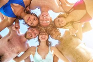 contento sorridente amici a il soleggiato spiaggia foto