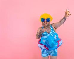 Grasso uomo con barba e parrucca mangia un gelato foto